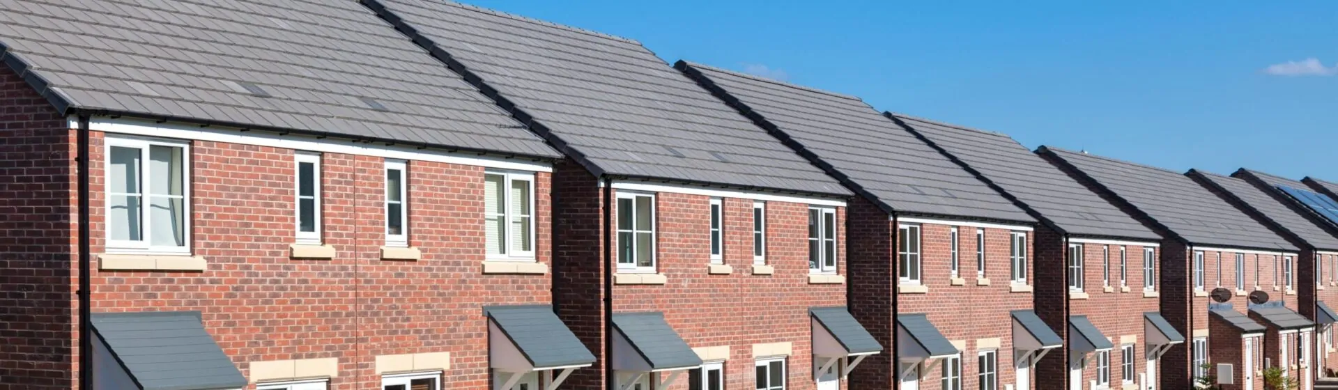 Modern red-brick terraced houses with front gardens, typical of properties assessed in a Level 2 HomeBuyer Survey.
